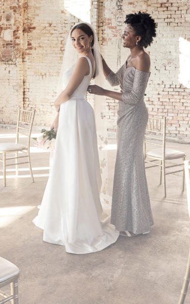 mother of the bride helping her daughter with her veil