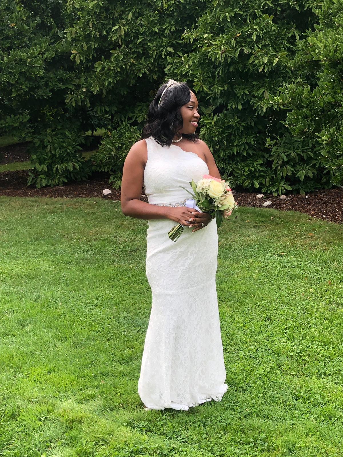 bride wearing a one shoulder sheath wedding dresses in backyard