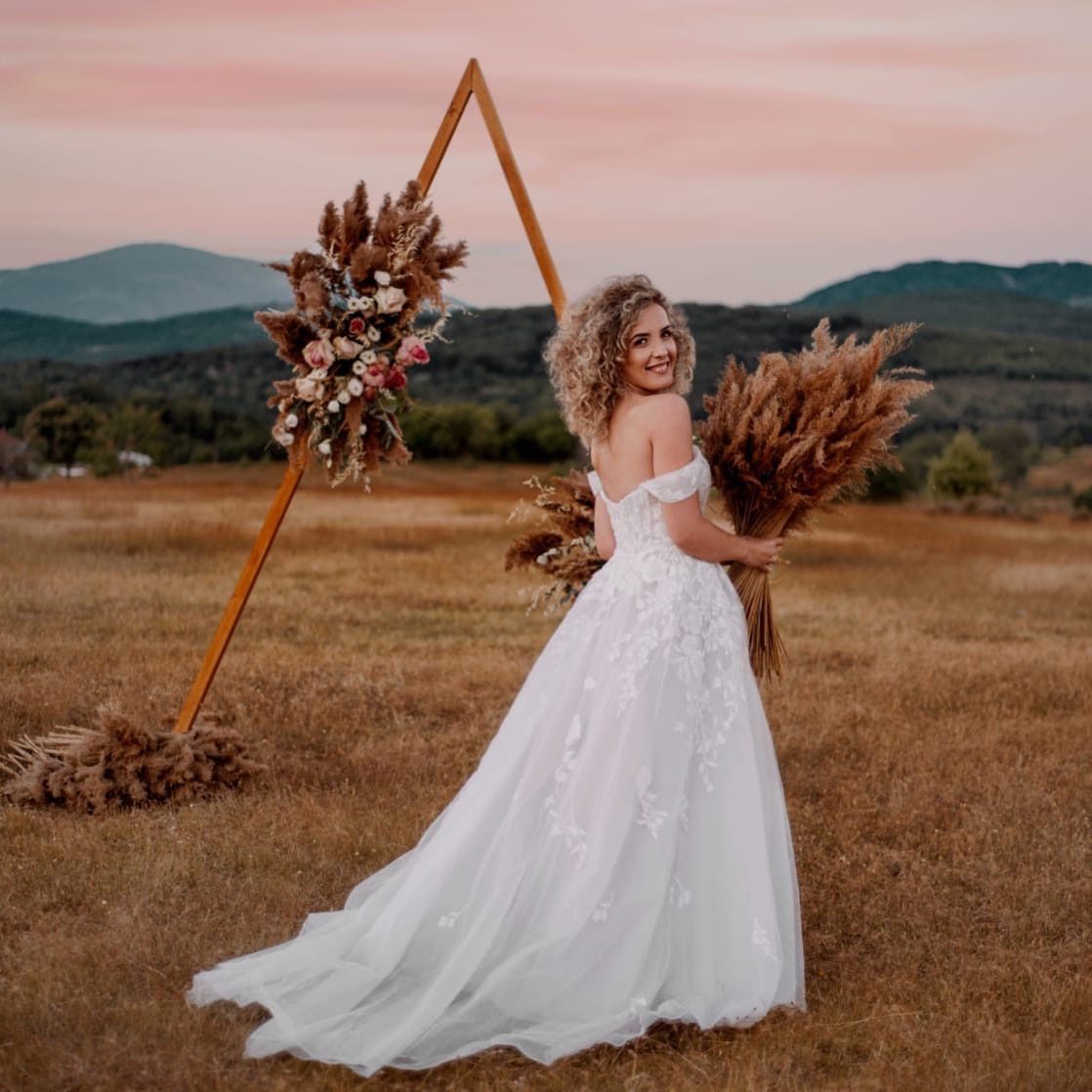 bohemian inspired bride standing in field 